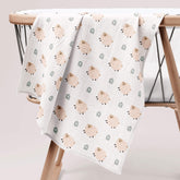 Fluffy sheep muslin swaddle draped over wooden baby rack